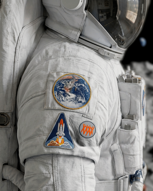 Astronaut suit with Earth, space shuttle and Team Créatif logo patches