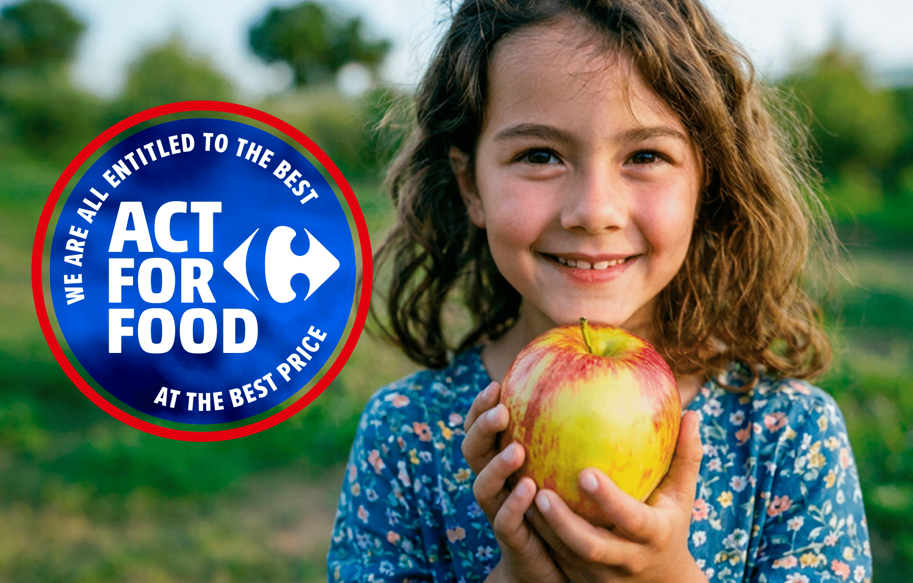 Smiling girl holding an apple next to Carrefour's Act for Food badge