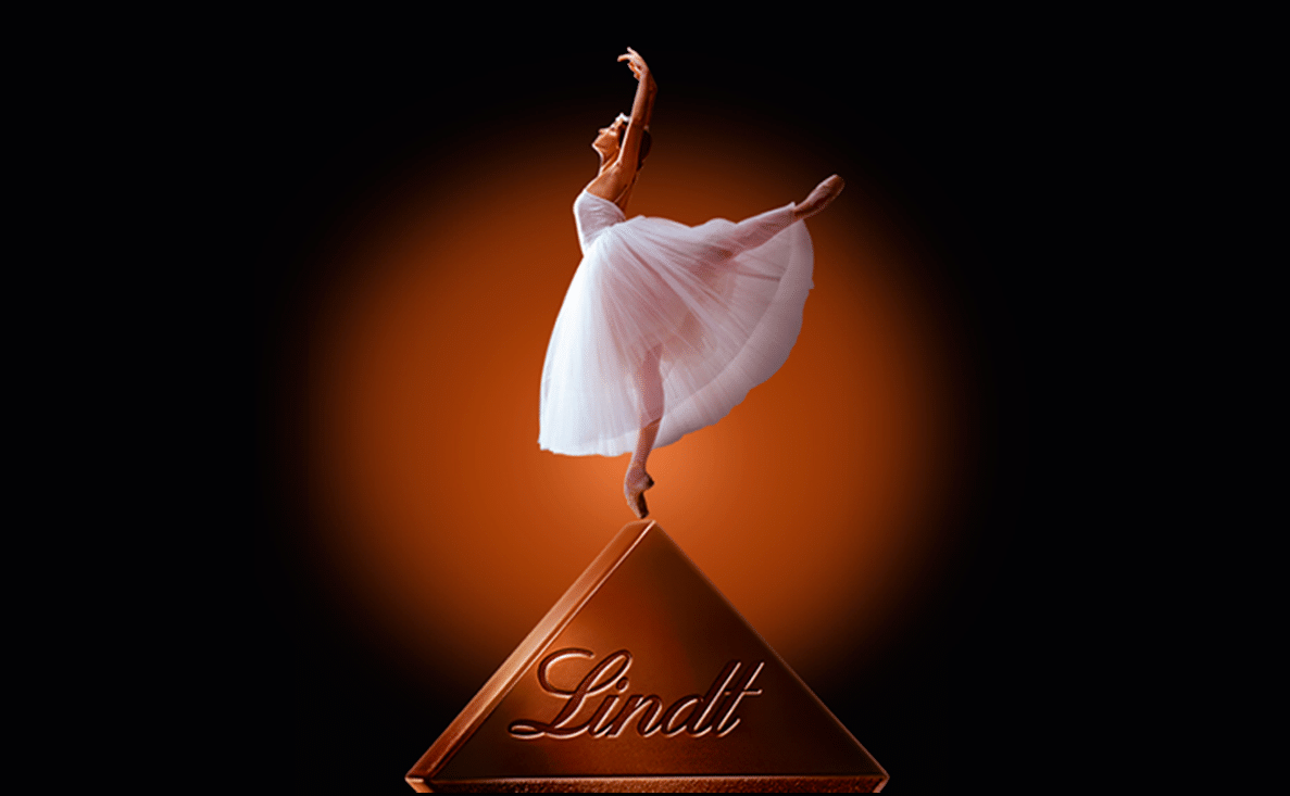 Ballerina on pointe on top of a Lindt chocolate diamond, orange glow on black