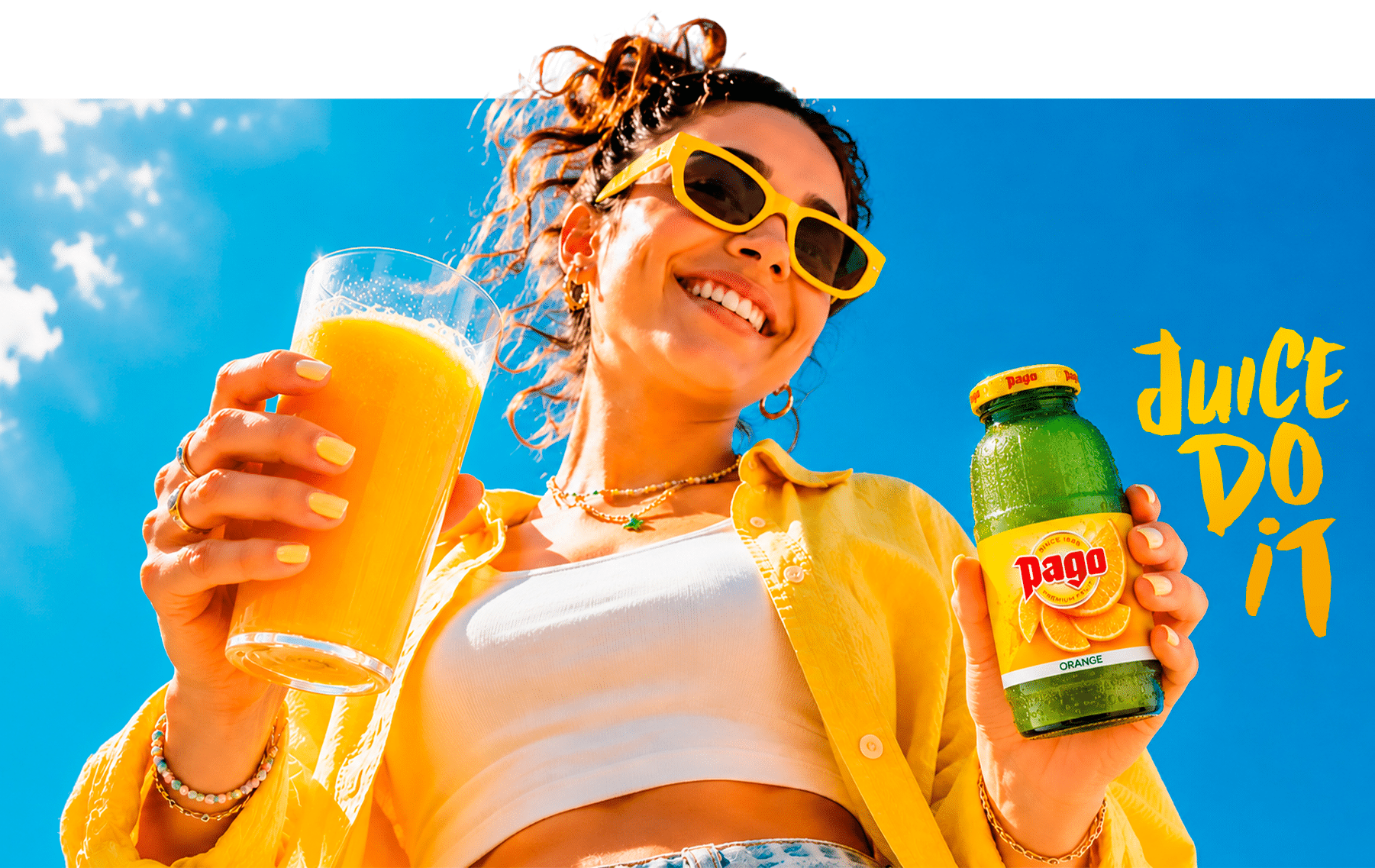 Young woman holding a glass of orange juice and a Pago Orange bottle, 'Juice do it'